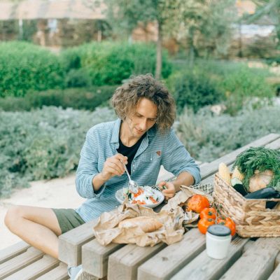 Woman in Gray Cardigan Sitting on Brown Wooden Bench